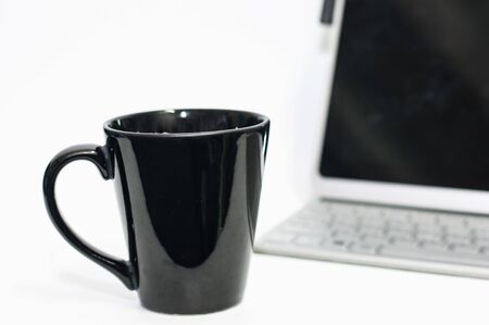 Coffee cup on white desk and laptop for background,drink between working,selective focus.の写真素材