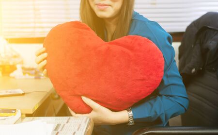 Heart red pillow shape in hand female,focus at pillow.の写真素材