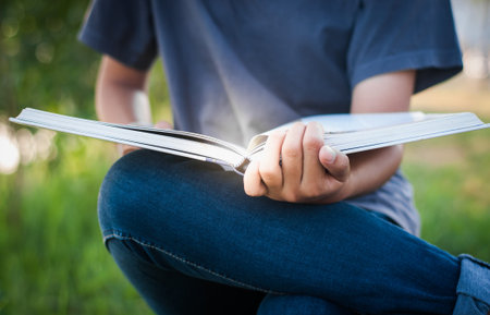 Young woman reading book in park,selective focus.