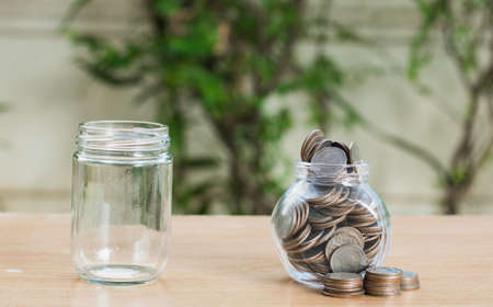 Saving money coin in bottle and empty bottle concept on table,selective focus.の写真素材