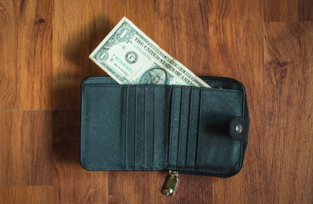 Wallet and money con wooden wall,selective focus.