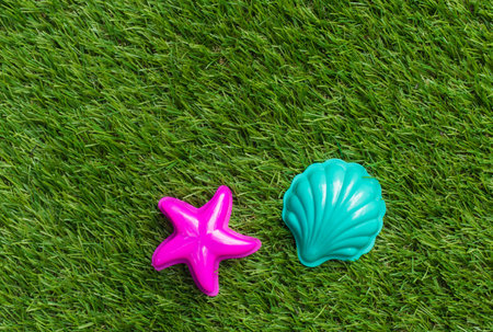 Children's plastic beach toy on grass background.