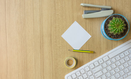 Flat lay white keyboard and other office supply on wooden table,with copy space.の写真素材