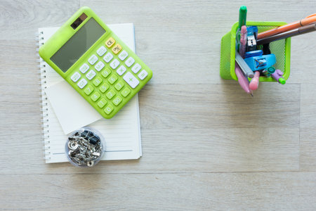 Flat lay of green calculator with other on work desk.の写真素材