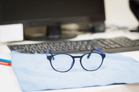 Glasses for working with computer on desk in office,soft focus.