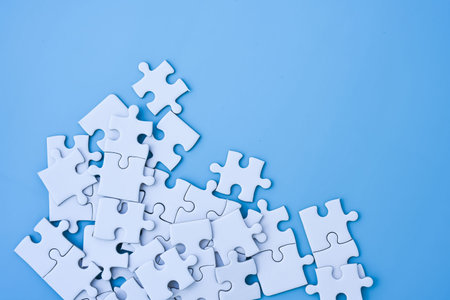 White jigsaw puzzle on blue background.の写真素材