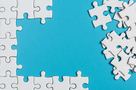 White jigsaw puzzle on blue background.の写真素材