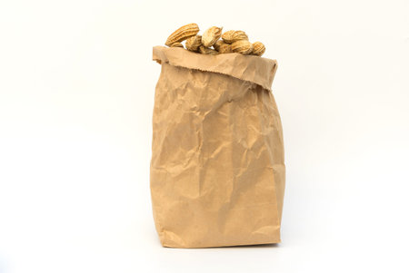 Peanut in brown paper bag on white background.