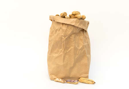 Peanut in brown paper bag on white background.の写真素材
