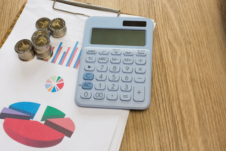 Stack of coin with calculator on work table,selective focus.の写真素材