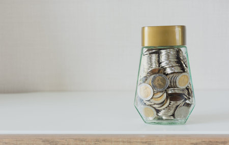 Saving money concept,coin money in glass bottle on work table,selective focus.
