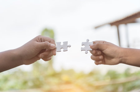 White jigsaw puzzle in child hand,team concept,soft focus.の写真素材