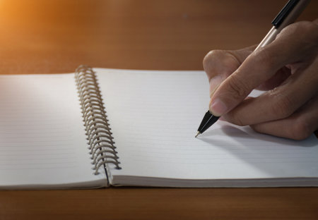Man writing with pen on notebook,selective focus.の写真素材