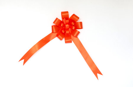Orange bow ribbon on white background.の写真素材