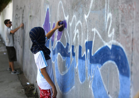 Sofia, Bulgaria - July 14, 2012: A graffiti artist is painting his artwork on a wall. He is participating in the annual Urban graffiti festival in Sofia.のeditorial素材