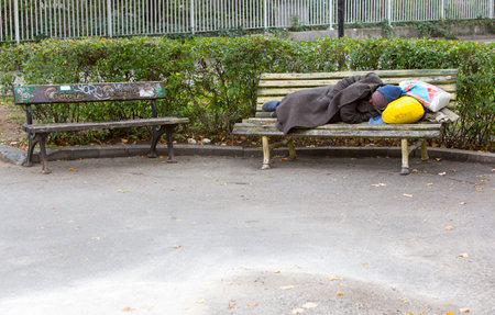 Sofia, Bulgaria - November 4, 2014: Homeless man is sleeping on a bench in the center of Sofia. Years after joining the EU Bulgaria is still the poorest country in the union.のeditorial素材