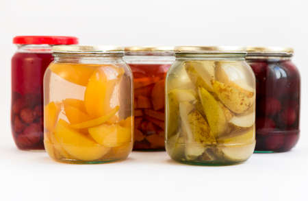 Peaches, pears, cherries, quinces and raspberries in jars isolated on white.の写真素材
