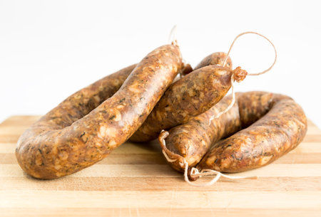 Three raw flat sausages on a cutting board. Traditional Bulgarian meat appetizer.の写真素材