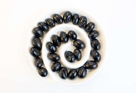 Black olives in a dish from above isolated on a white background.の写真素材
