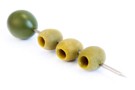 Three green olives on a stick isolated on a white background.の写真素材