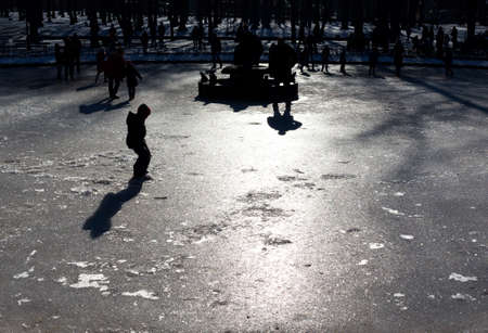 Children are playing on the surface of a frozen fountain.の写真素材