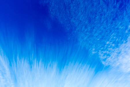 Skyscape with wispy clouds against the colorful blue sky