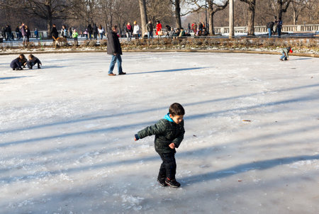 Sofia, Bulgaria - January 11, 2015: A child is playing on the surface of a frozen fountain in a park in Sofia.のeditorial素材