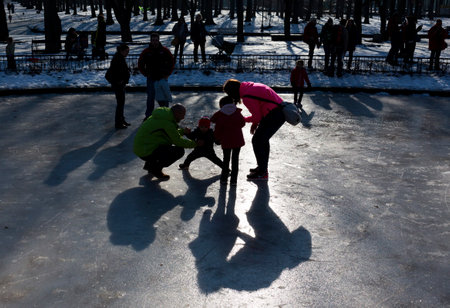 Sofia, Bulgaria - January 11, 2015: A family is playing on the surface of a frozen fountain in a park in Sofia.のeditorial素材