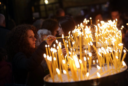 Sofia, Bulgaria - April 10, 2015: An young woman is lighting candles in a church in Sofia at Easter.