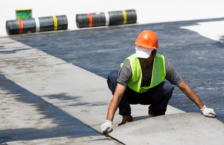 Sofia, Bulgaria - May 21, 2015: Construction workers are waterproofing a bridge surface floor at a...