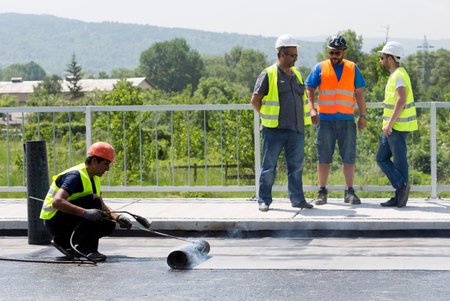 Sofia, Bulgaria - May 21, 2015: Construction workers are waterproofing a bridge surface floor at a highway in Sofia.のeditorial素材