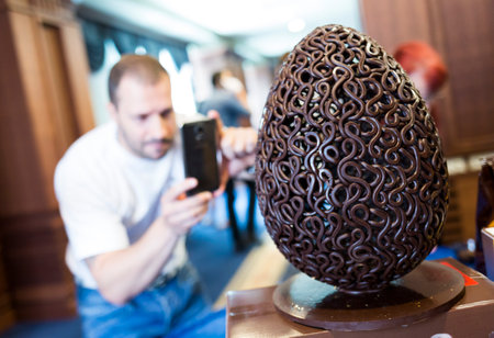 Sofia, Bulgaria - May 16, 2015: A man is photographing a handmade chocolate egg shown on an event for handmade chocolate productions.のeditorial素材