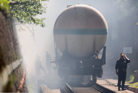 Sofia, Bulgaria - May 19, 2015: Oil tanker train is seen in smoke near Sofia. Fire safety and civil protection service at Fire department is training in a situation of train crash with spilled toxic and flammable materials from the cargo tanks.のeditorial素材