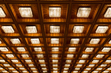 Many old vintage lamps on a wooden ceiling.の写真素材
