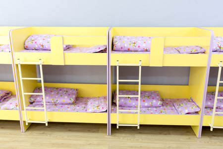 Modern kindergarten bedroom with small bunk beds with stairs for the kids.