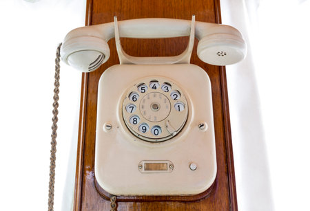 Really old rotary telephone in the wall of a retro train.
