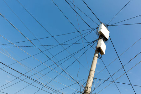 Power pole with white boxes with many electric cables in gypsy neighborhood in Sofia, Bulgaria.