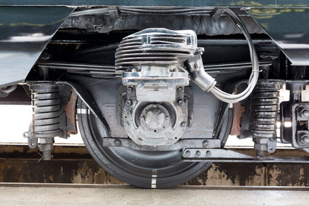 Old authentic green passenger trains in a depot for renovation before being used for tourist trips across Europe. Details of the train's transmission.の写真素材