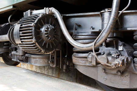Old authentic green passenger trains in a depot for renovation before being used for tourist trips across Europe. Details of the train's transmission.の写真素材