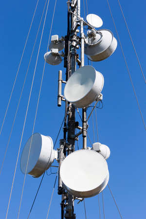 Telecommunications tower against the blue sky. Antennas for television, radio, and mobile phones.の写真素材