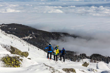 Three skiers are looking at a slope of Vitosha mountain. They are participating in an freestyle competition of skiers and snowboarders during the weekend.の写真素材