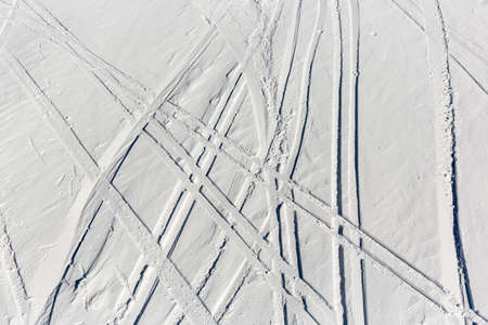 Ski trails are seen from a aerial view of off-piste ski slope in a mountain top near a ski resort.の写真素材