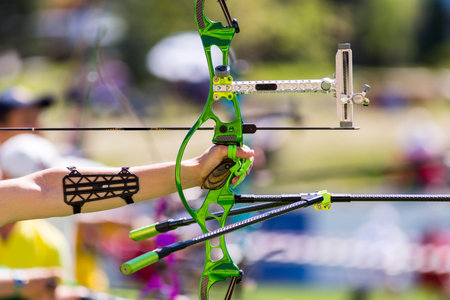 Person is shooting with recurve bow during an archery competition. Hand and bow only. Green bow.の写真素材