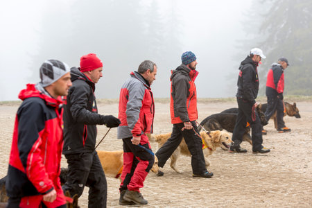 Sofia, Bulgaria - April 20, 2016: Men and their dogs at the search and rescue team at Bulgarian Red Cross are participating in a training in the foggy mountain.のeditorial素材