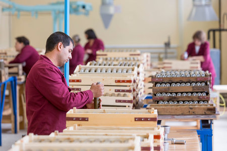Sopot, Bulgaria - May 17, 2016: Worker is checking explosive element of anti tank rocket-propelled grenades (RPGs, bazooka) near an assembly line in a munition factory. Working in dangerous conditions.のeditorial素材