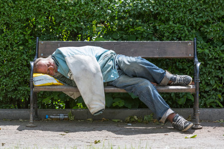 Sofia, Bulgaria - May 18, 2016: Homeless man during day sleeping on a bench in a park.のeditorial素材
