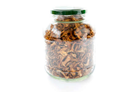 Dried chanterelle mushrooms in a jar isolated on a white background.の写真素材