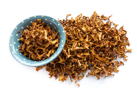 Dried chanterelle mushrooms in a bowl isolated on a white background.の写真素材
