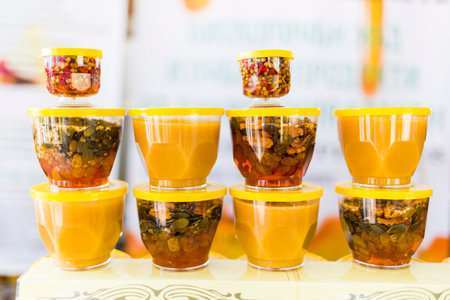 Honey with dried fruits and dried nuts - walnuts, hazelnuts, peanuts, almonds, cashews, plums,...