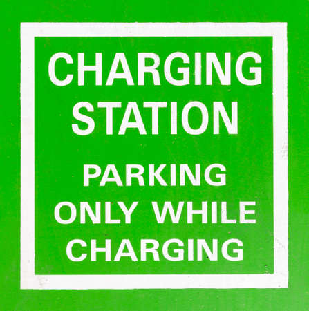Electric Vehicle Charging Station green road sign. Parking only while charging. An electric car is an automobile that is propelled by one or more electric motors, using electrical energy stored in rechargeable batteries.の写真素材